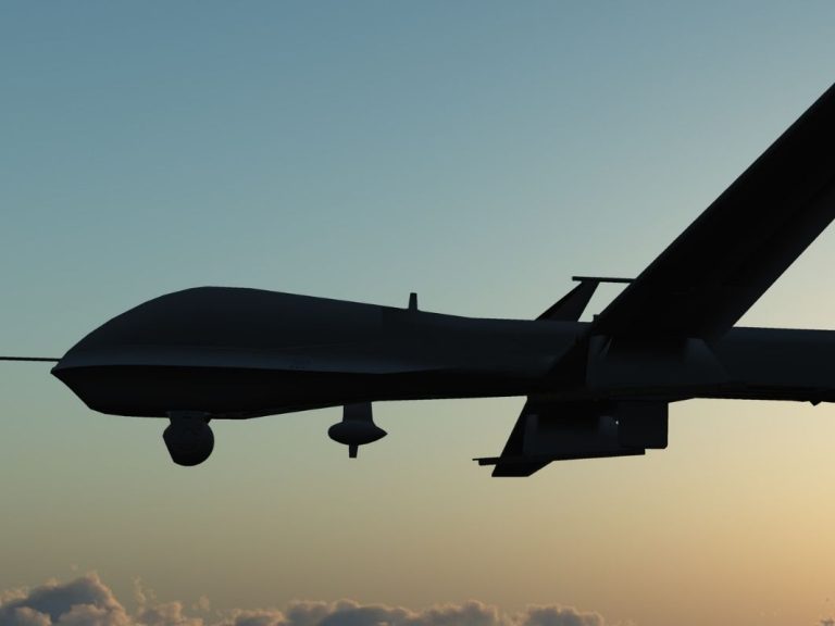 A military drone flying above the clouds.
