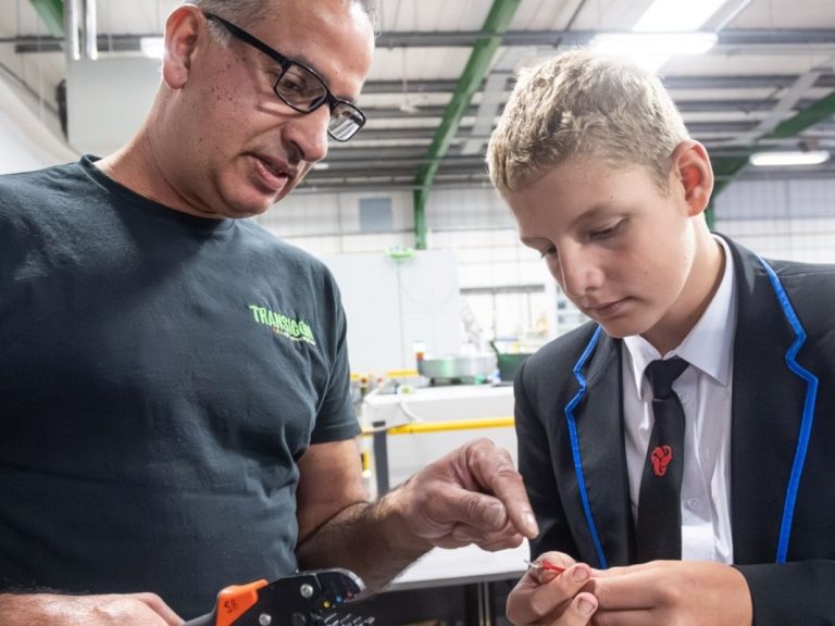 An engineer advising a student during a practical exercise.