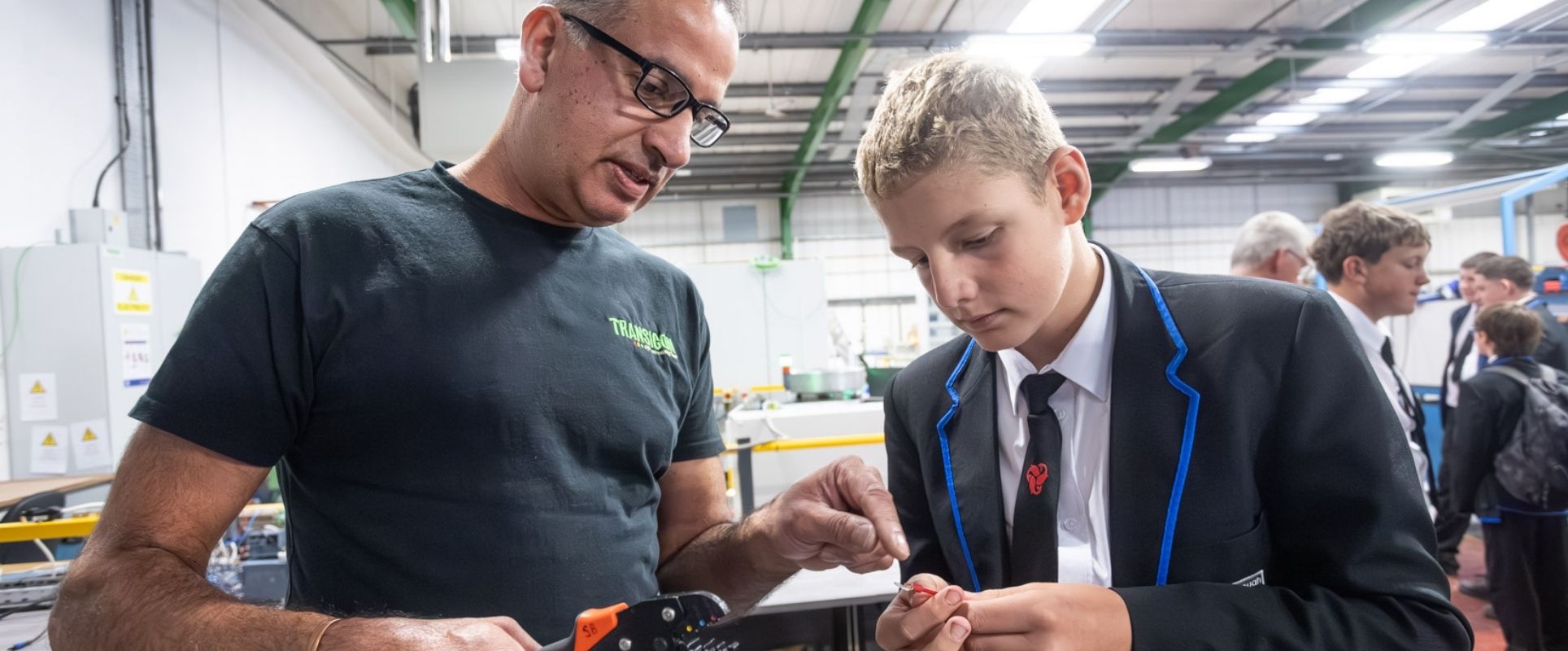 An engineer advising a student during a practical exercise.